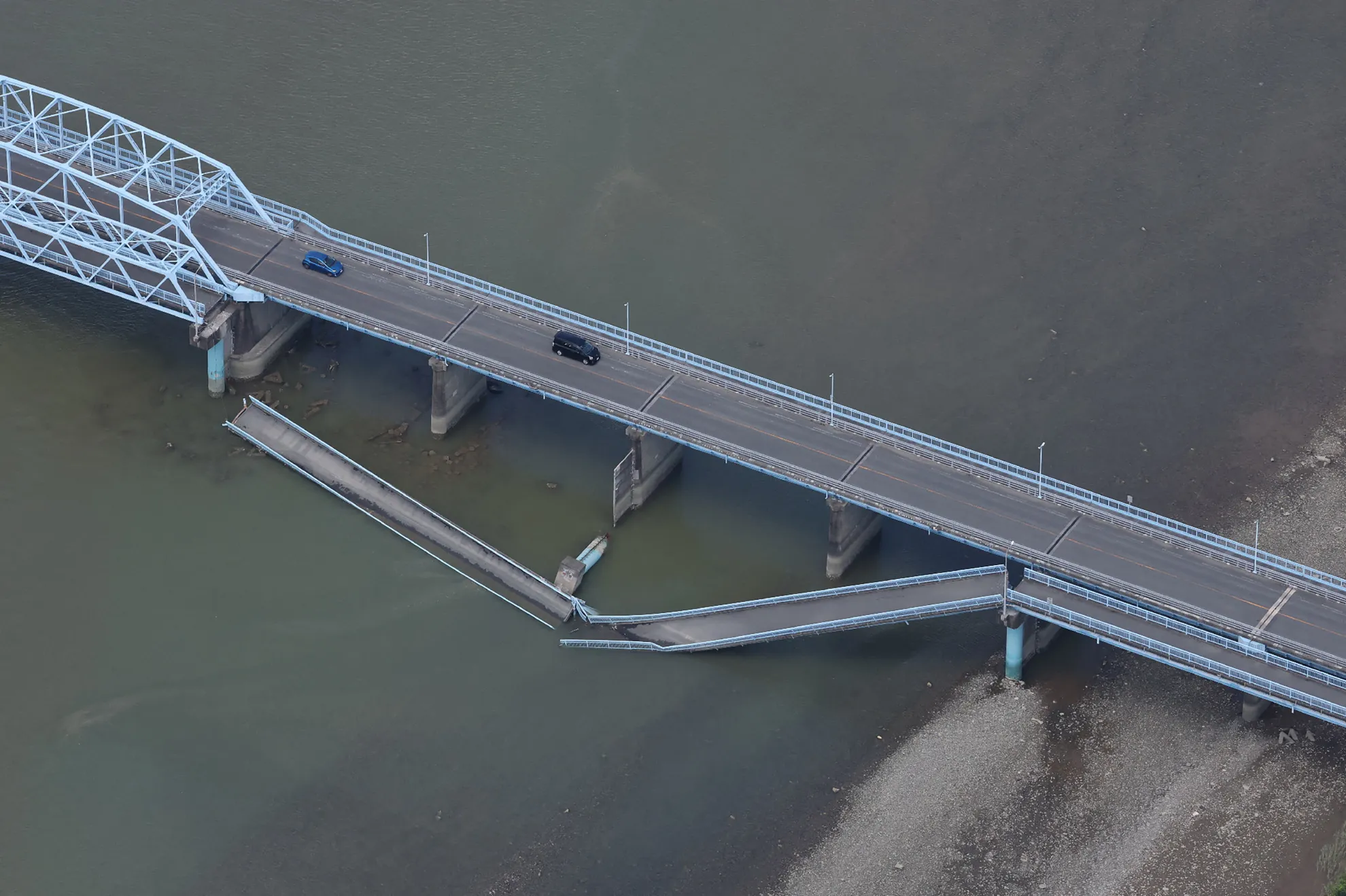 Mobil-mobil melaju di Jembatan Ueyanagi yang runtuh sebagian di Yatsushiro, Prefektur Kumamoto, pada Rabu (29/7/2026), setelah gempa bumi melanda Jepang barat daya pada hari sebelumnya.